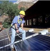 man on roof with solar power panels